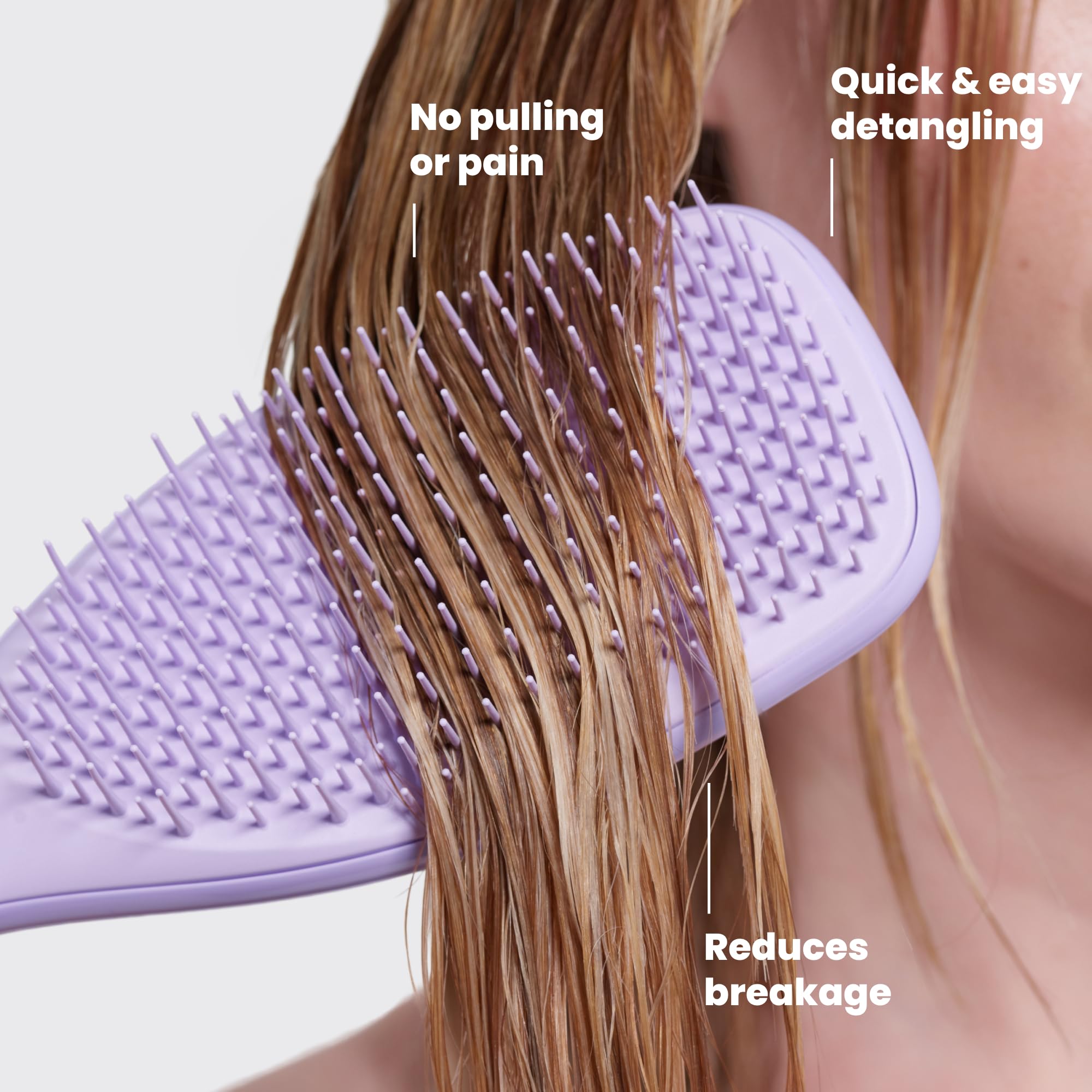 TANGLE TEEZER held in hand to show compact size and ergonomic control benefit