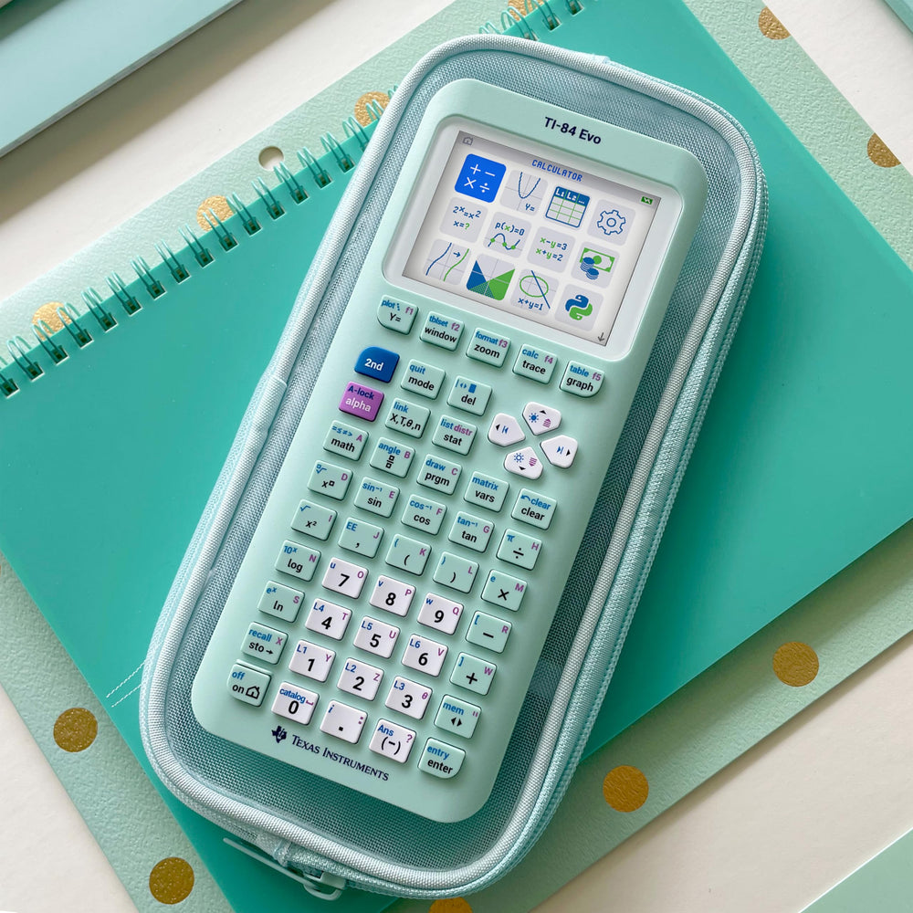 Texas Instruments TI-84 Evo beside a notebook showing compact size and school-ready portability