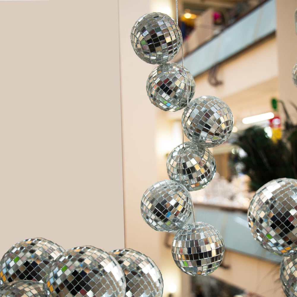 The Dreidel Company hanging cluster of mirror balls creating dynamic ceiling reflections