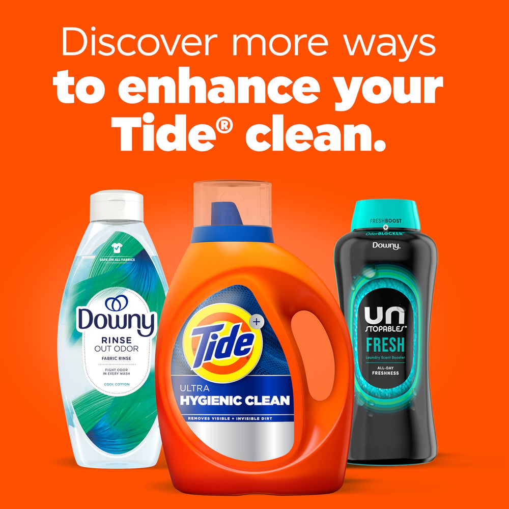 Tide Ultra Hygienic Clean bottle next to measuring cup and folded laundry showing 94-load supply
