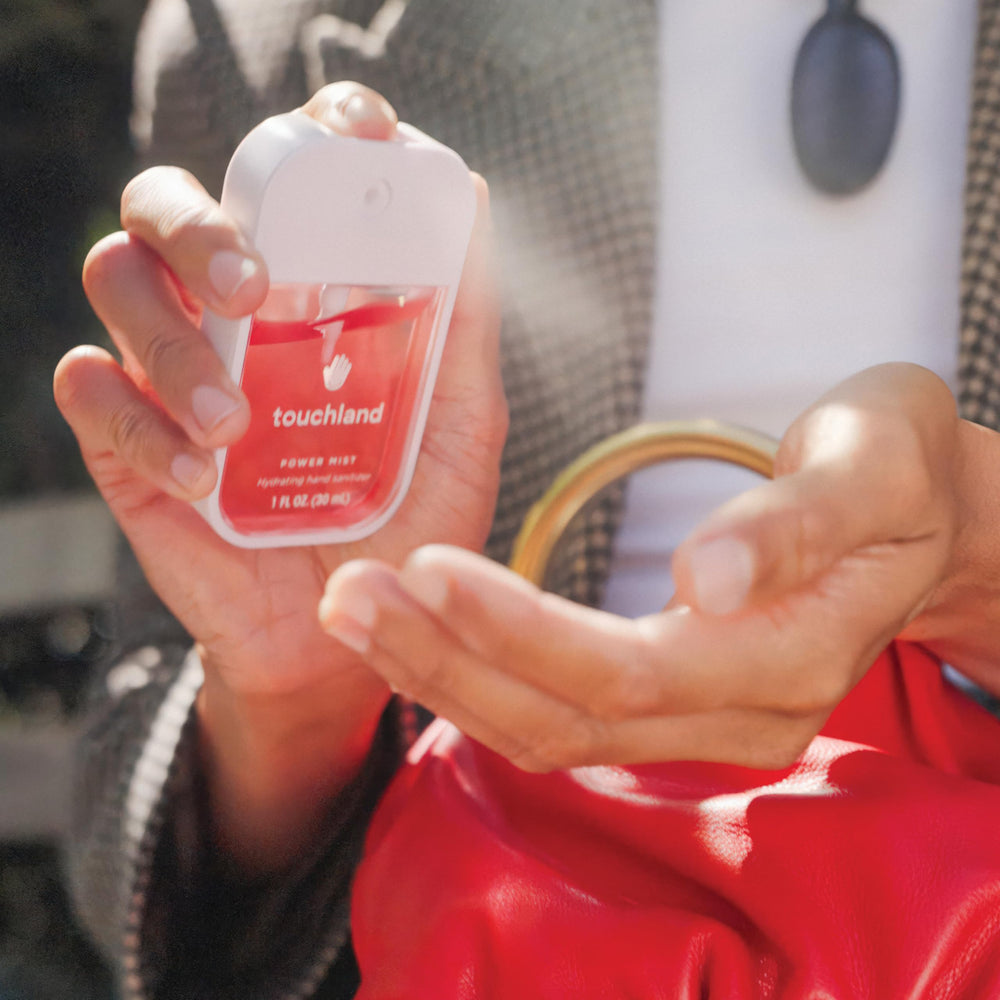 Touchland hand sanitizer in use outdoors showing on-the-go hygiene and hydration