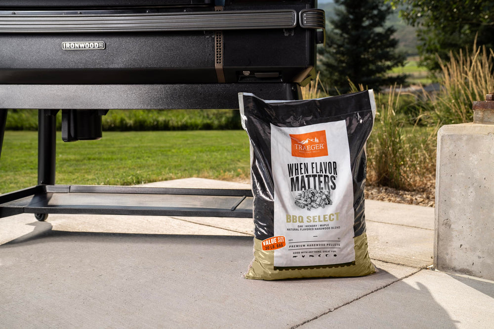 Traeger grill in use with visible smoke, showing clean flavorful burn