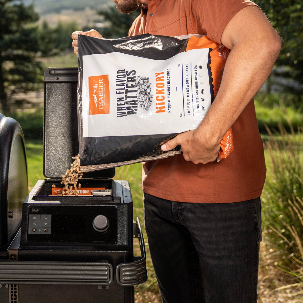 Traeger pellets feeding into a grill burn pot demonstrating steady burn performance