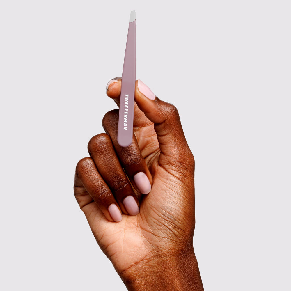 Tweezerman slant tweezer Purple Wisteria packaging flatlay highlighting retail-ready presentation and gift appeal
