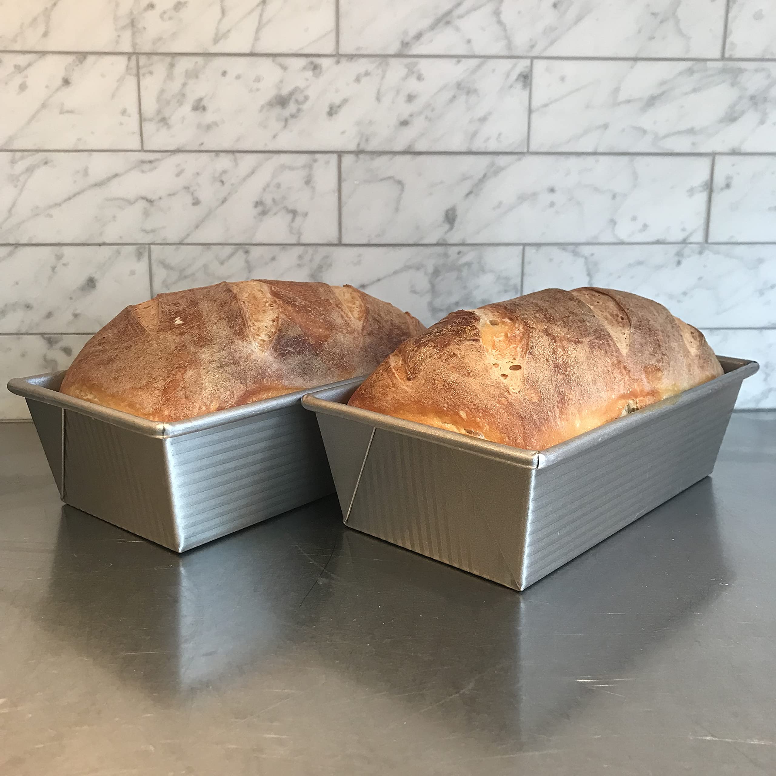 USA Pan loaf pan held by hand to show scale and ease of handling