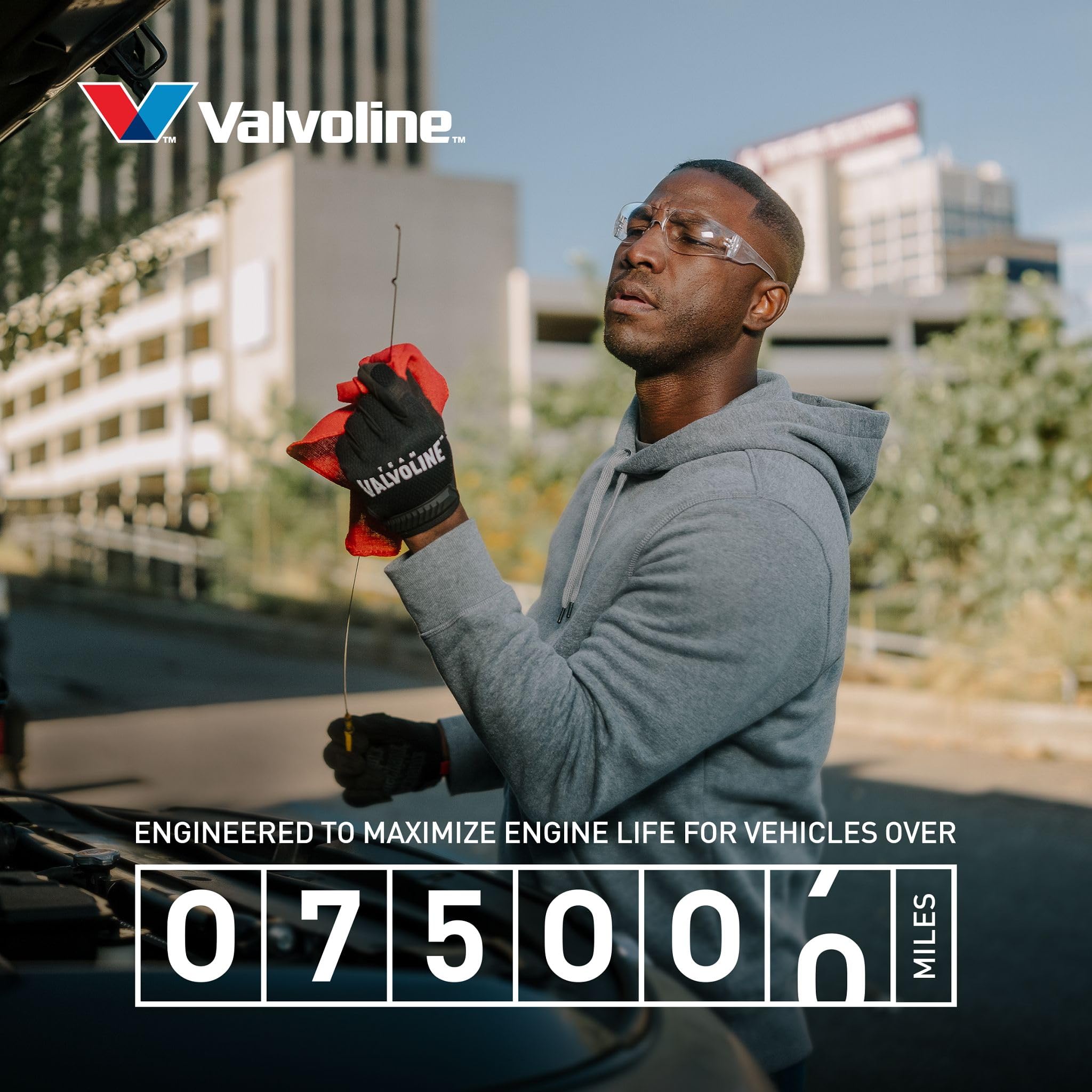 Valvoline jug beside a parked car in driveway showing real-world maintenance benefit