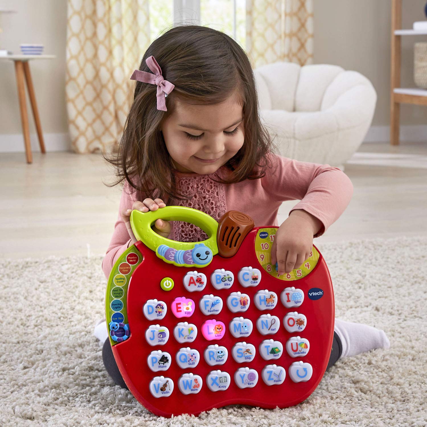 VTech ABC Learning Apple held in a toddler hand illustrating compact, travel-friendly size